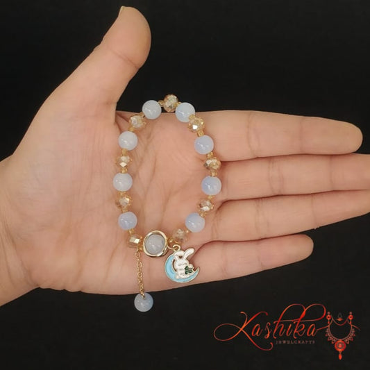 Soft blue and gold toned beads, with a moon and bunny charm