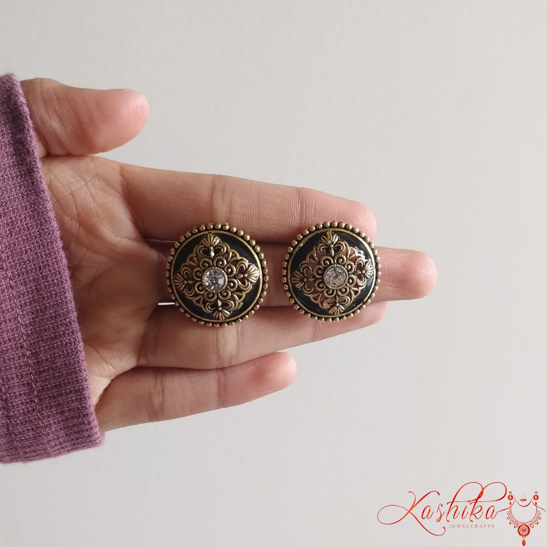 Round stud earrings with intricate gold-tone floral detailing